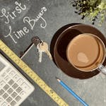 Flat lay of keys, calculator, and coffee, perfect for first-time homebuyers concept.